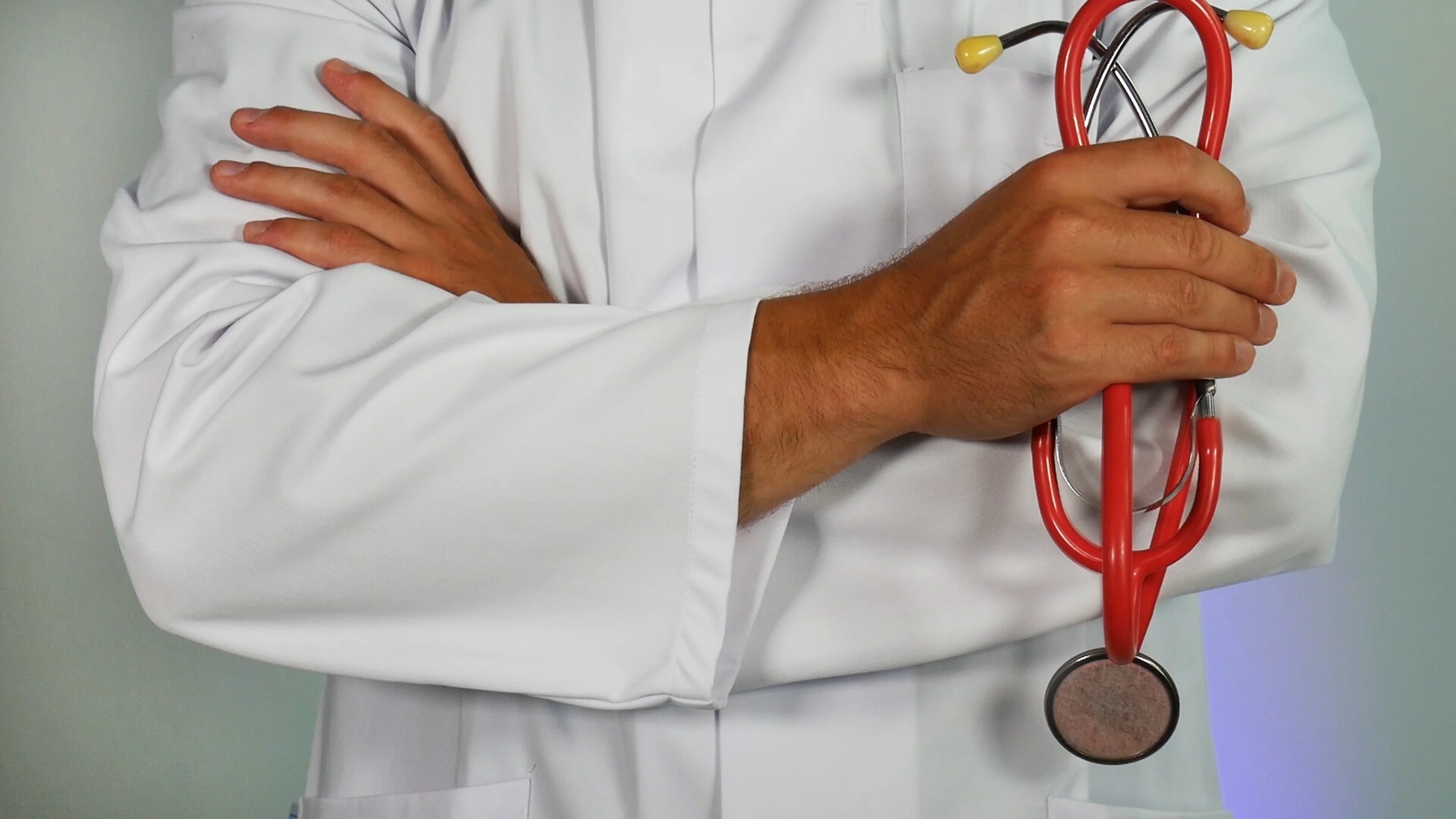 Doctor in white coat holding stethoscope.